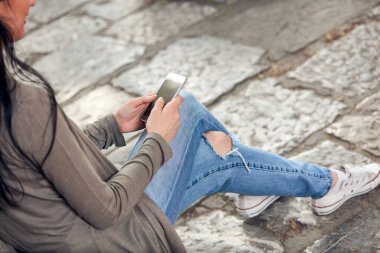 Sokakta akıllı telefon kullanan hoş bir bayan..