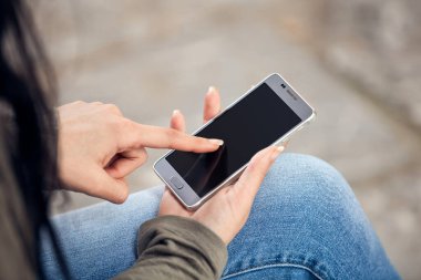 Sokakta akıllı telefon kullanan hoş bir bayan..