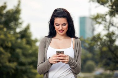 Sokakta akıllı telefon kullanan hoş bir bayan..