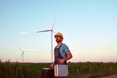 Yel değirmeni çiftliği parkında mühendis. Rüzgar türbinlerini kontrol ediyor ve hizmet ediyor..