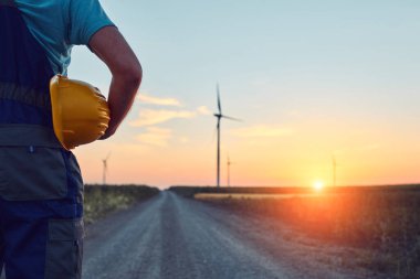 Yel değirmeni çiftliği parkında mühendis. Rüzgar türbinlerini kontrol ediyor ve hizmet ediyor..