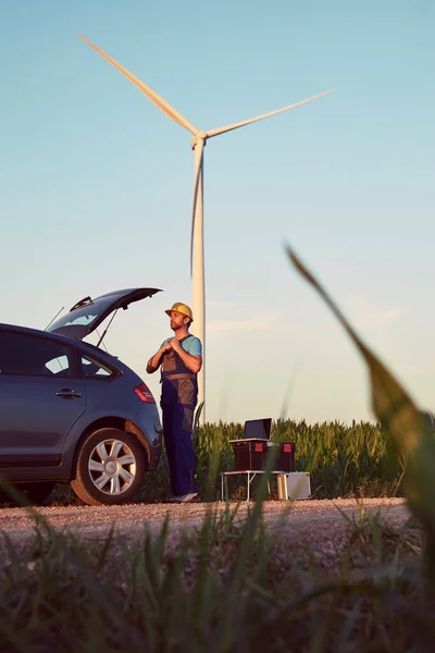 Engineer mechanic in a windmill farm park checking and servicing wind turbines.