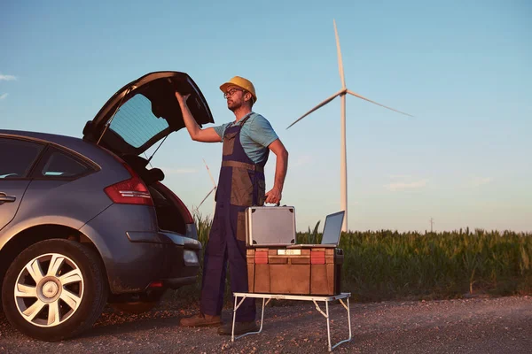 Engineer mechanic in a windmill farm park checking and servicing wind turbines.