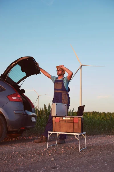 Engineer mechanic in a windmill farm park checking and servicing wind turbines.