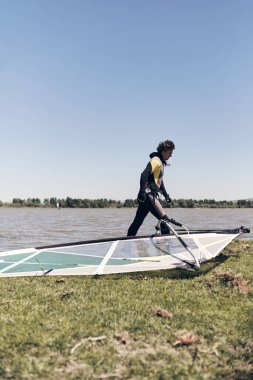 Rüzgârlı bir yaz günü gölde rüzgar sörfçüsü.