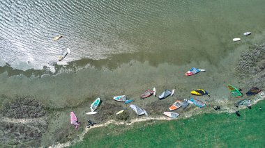 Göl kıyısında rüzgar sörfü kampı.