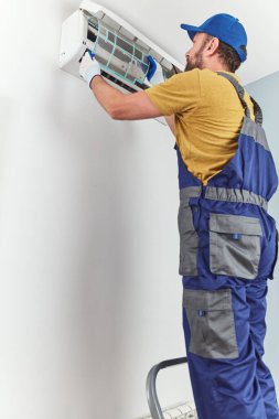 Tamirci içeride temizlik ve havalandırma ünitesini tamir ediyor..