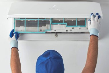 Tamirci içeride temizlik ve havalandırma ünitesini tamir ediyor..