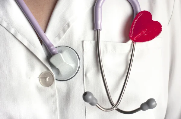 Doctor with a heart shaped lollipop. — Stock Photo, Image