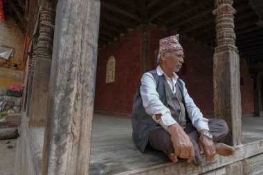 Bhaktapur, Nepal - Ekim 2021: 9 Ekim 2021 'de Katmandu Vadisi, Nepal' de Bhaktapur 'da bir sokakta dinlenen bir adam.