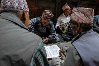 Bhaktapur, Nepal - Ekim 2021: Erkekler 10 Ekim 2021 'de Katmandu Vadisi, Nepal' de Bhaktapur 'daki Bhairabnath Tapınağı önünde şarkı söylüyorlar.