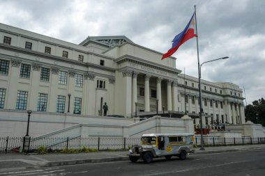 Manila, Filipinler - Mart 2022: 27 Mart 2022 tarihinde Manila, Filipinler 'de Ulusal Güzel Sanatlar Müzesi' nin önünden geçen bir jeepney.