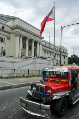 Manila, Filipinler - Mart 2022: 27 Mart 2022 tarihinde Manila, Filipinler 'de Ulusal Güzel Sanatlar Müzesi' nin önünden geçen bir jeepney.