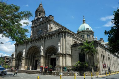 Manila, Filipinler - Mart 2022: Intramuros 'taki Manila Katedrali' nin yanından geçen insanlar 22 Mart 2022 'de Manila, Filipinler' de.