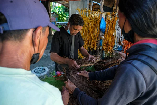Zamboanguita, Filipinler - Haziran 2022: 15 Haziran 2022 tarihinde Malatapay pazarında tütün satan bir adam Zamboanguita, Negros Oriental, Filipinler.