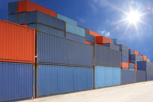 Стек вантажних контейнерів на контейнерному подвір'ї з променями сонця — стокове фото