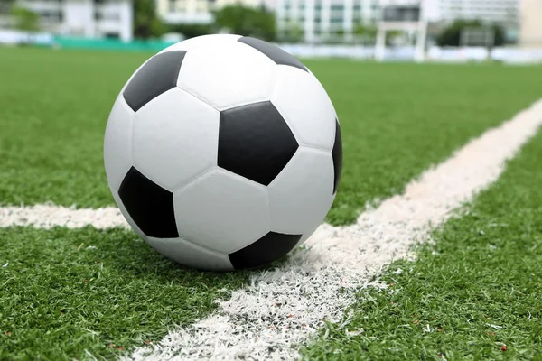 Pallone da calcio a punta su angolo, con gol e campo — Foto Stock