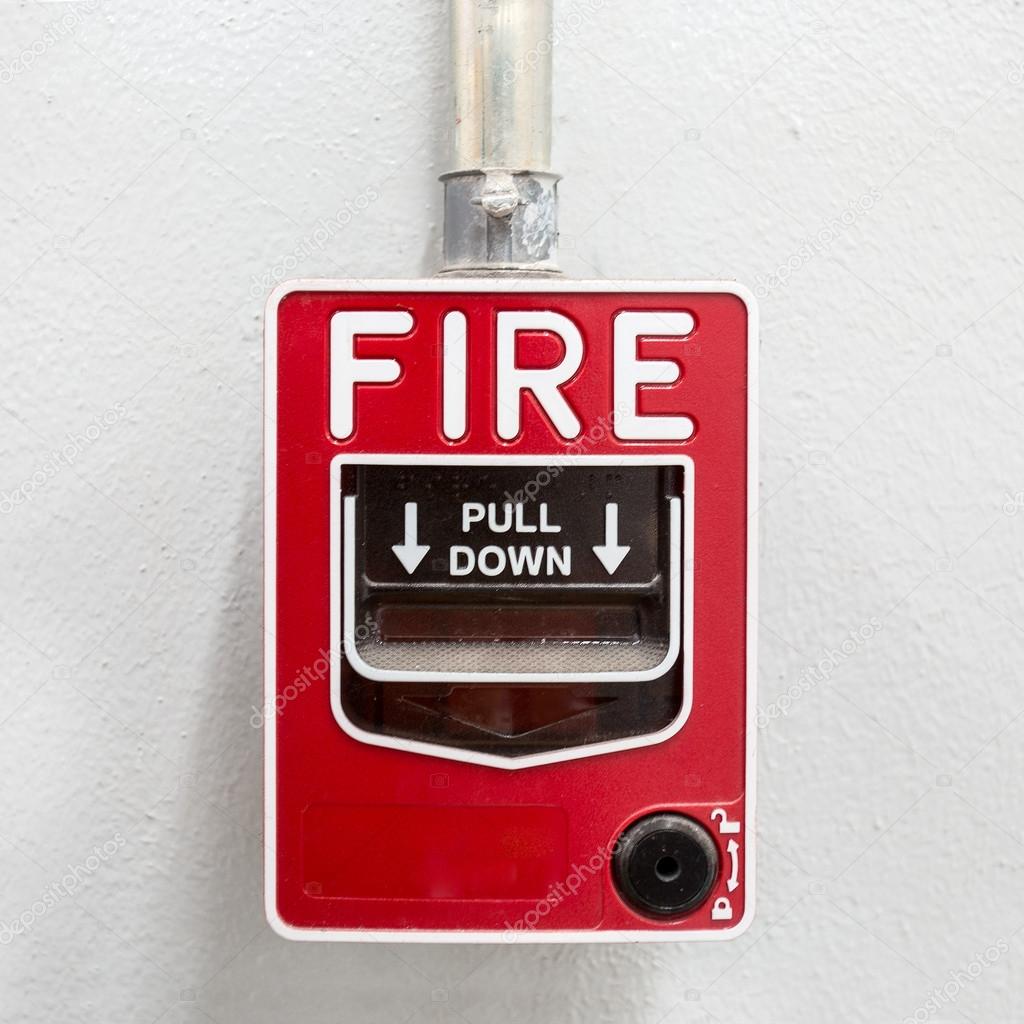 Fire alarm on white wall used to report a fire on the premises
