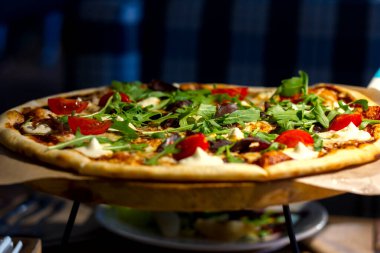 Etli taze pizza, domates ve mozzarella peynirli otlar.