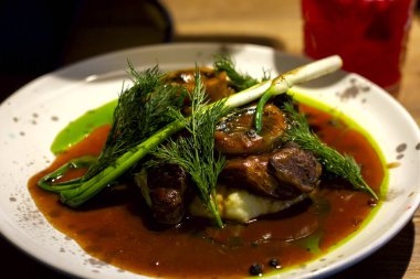 Restoran osso-buco biftek tabağı otlarla süslenmiş.