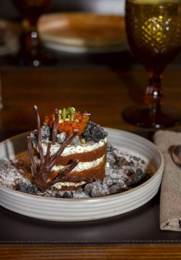 Çikolata desenli dutlu güzel bisküvi pastası yakın plandaki bir restoranda beyaz bir tabakta.