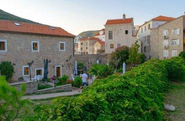 Karadağ - Budva: 8 Eylül 2021: Eski Budva kasabası ve turistler. Antik binalar ve yeşil alanlı miras alanı.