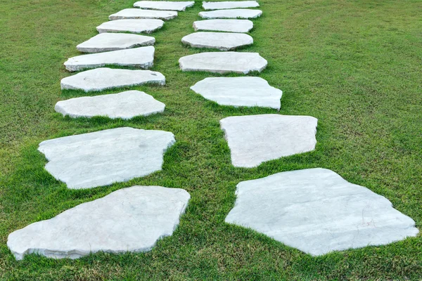 Каменная дорожка с зеленой травой — стоковое фото