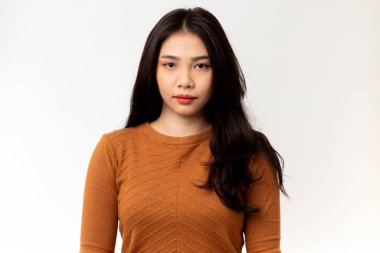 Beyaz arka planda turuncu gömlek giyen Asyalı bir kadının portresi..