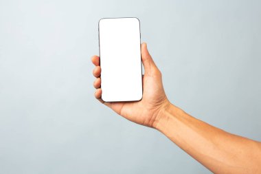 Mavi arkaplanda kırpma yolu ile izole edilmiş boş ekran ile cep telefonu tutan el işi adamı