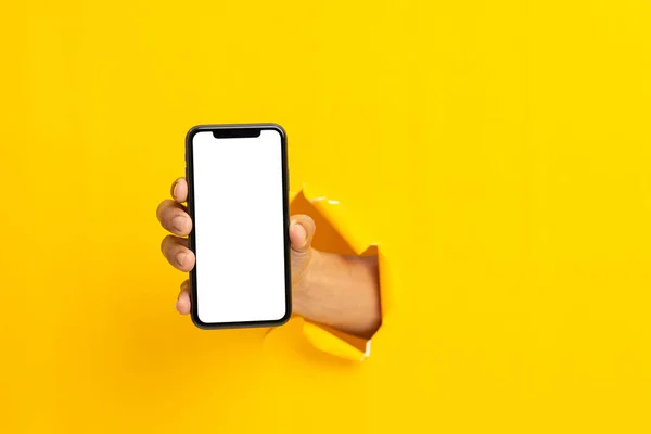 man hand holding a blank screen smart phone on a yellow backgroun