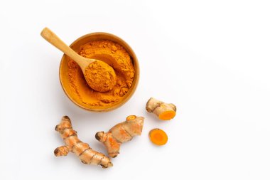 Beyaz arkaplanda izole edilmiş zerdeçal tozu ve zerdeçal kökü, üst görünüm