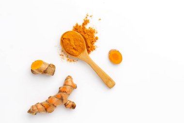 Beyaz arkaplanda izole edilmiş zerdeçal tozu ve zerdeçal kökü, üst görünüm