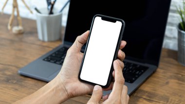 Hands of a businessman using a  smartphone mockup at his desk, Mobile phone blank screen for editing graphics.