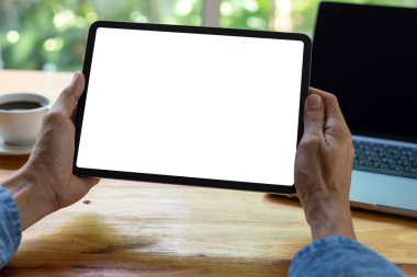 Boş ekran tableti, iş adamı tableti üzerinde çalışıyor. Ofisteki ahşap masada reklam metni için boş bir ekran kullanıyor.