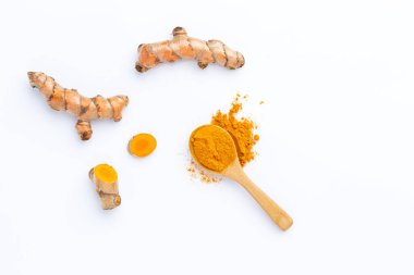 Beyaz arkaplanda izole edilmiş zerdeçal tozu ve zerdeçal kökü, üst görünüm