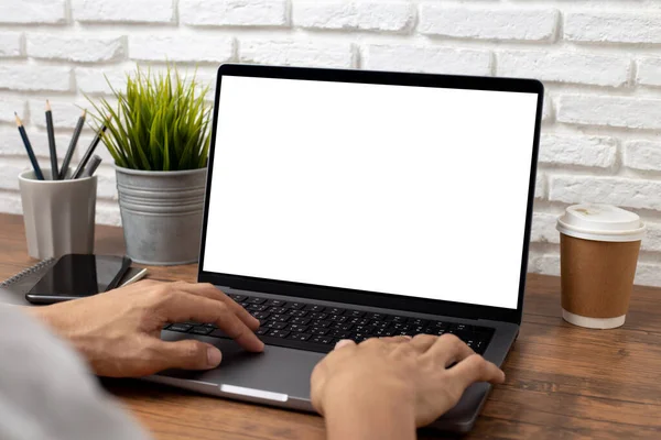 mock up empty screen notebook, businessman working on his laptop computer with blank space screen for advertising text on wood desk in office