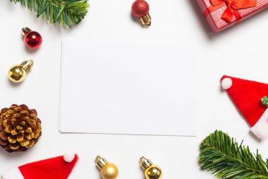 En iyi Noel kompozisyonu. Hediyeler, çam kozalakları ve Noel Baba Şapkaları beyaz arka planda kırmızı süslemeler. Mutlu yıllar konsepti.