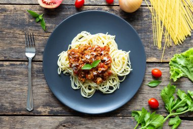 Tahta arka planda siyah tabakta spagetti. en üstteki görünüm