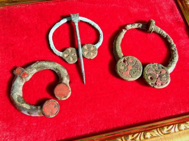 Antika bronz mücevherler: 3.-5. yüzyılın emelerinin olduğu broşlar. AD Doğu Avrupa. Kyiv kültürü. Çerçevedeki kırmızı bir bezin üzerinde