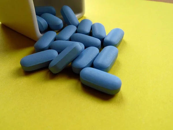 tablets with vitamins on a yellow background close-up