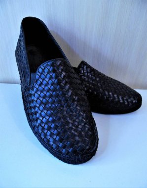 men's shoes loafers made of interlaced black leather on a white background