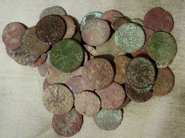Copper coins of Europe of the 17th century on a green cloth, close-up