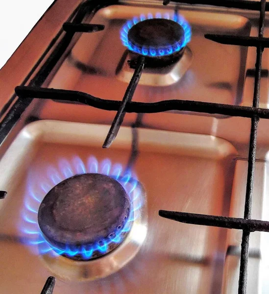 Gas stove at home, propane natural gas burns in the kitchen, blue flames of burners for cooking. The concept of the economy of Ukraine and Europe, the cost of gas, heat, EU sanctions, crisis, embargo