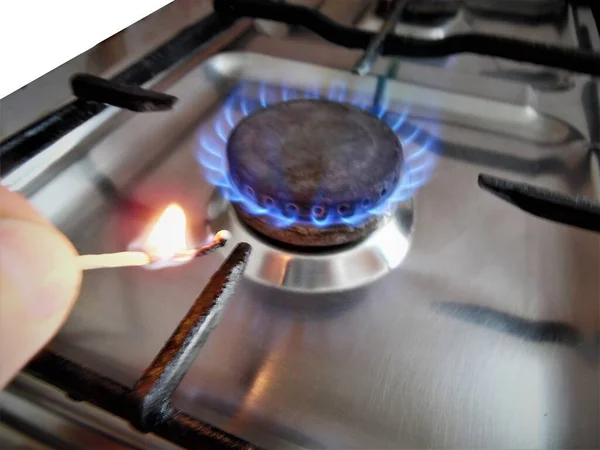 Gas stove at home, propane natural gas burns in the kitchen, blue flames of burners for cooking. The concept of the economy of Ukraine and Europe, the cost of gas, heat, EU sanctions, crisis, embargo