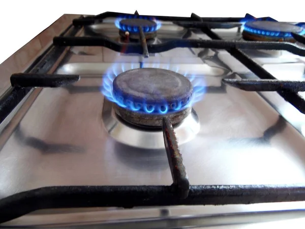 Gas stove at home, propane natural gas burns in the kitchen, blue flames of burners for cooking. The concept of the economy of Ukraine and Europe, the cost of gas, heat, EU sanctions, crisis, embargo