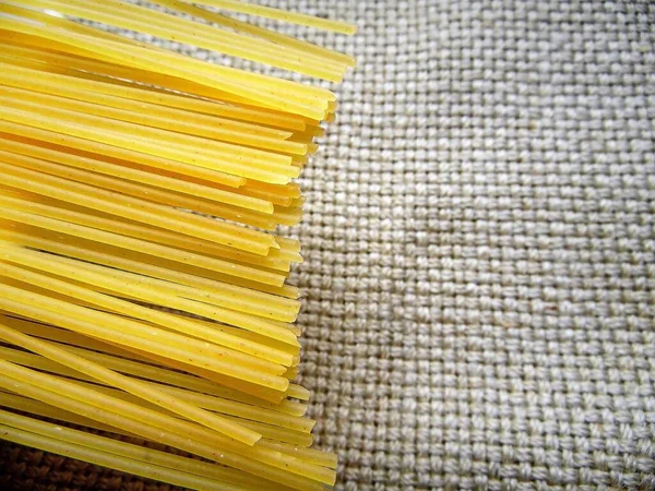 spaghetti pasta on a light dish against a background of coarse fabric