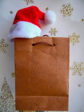 Noel Baba şapkası açık arkaplanda hediye paketi ve kar taneleri, Noel teması