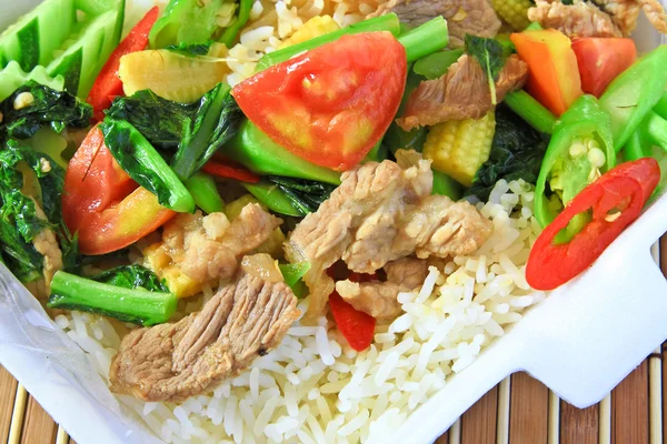 Verduras fritas con cerdo sobre arroz . Imagen de stock