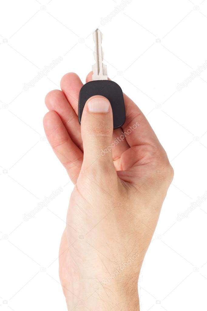 Male hand holds car key isolated on white background