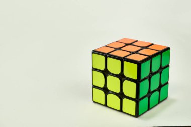 Beyaz arka planda sarı, yeşil ve turuncu rubik küpünü çözdük..